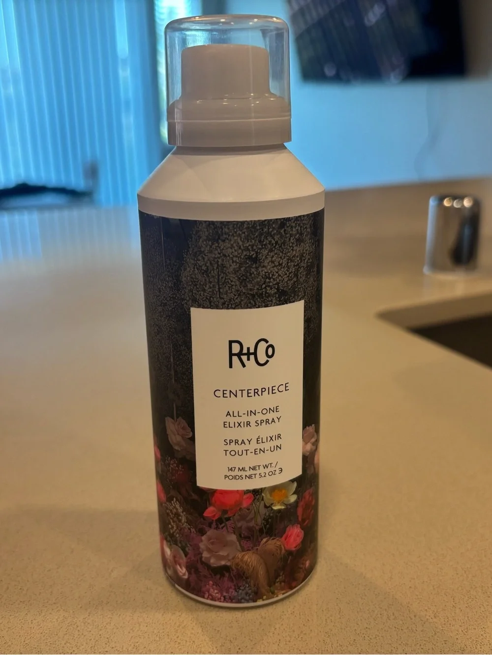 R+Co Centerpiece All-In-One Elixir Spray — White and Black Floral Can